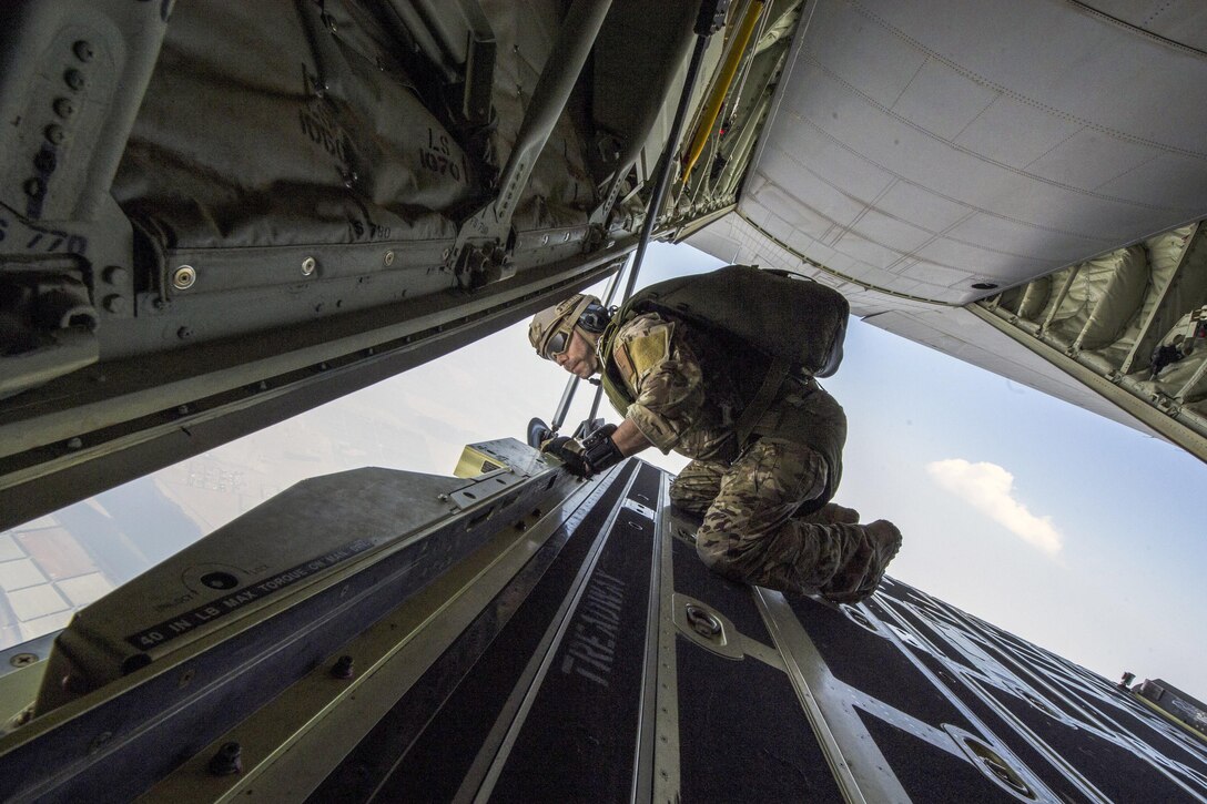 An airman looks out from an aircraft opening.