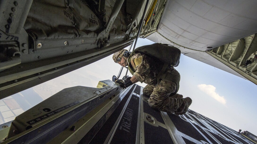 An airman looks out from an aircraft opening.