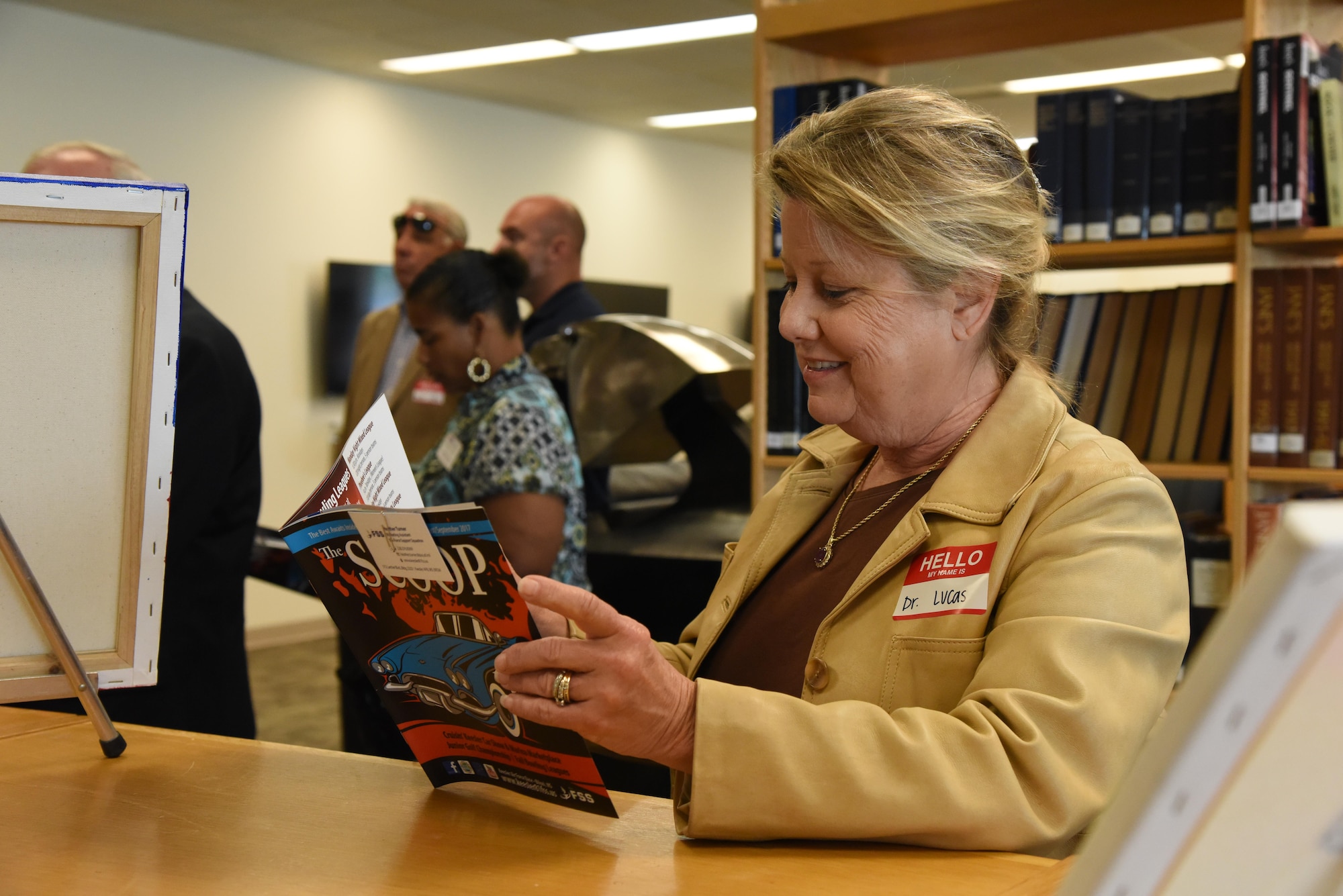 Dr. Karen Lucas, Tulane University of Continuing Studies associate dean, views a copy of The Scoop while touring the McBride Commons during an honorary commanders 81st Mission Support Group orientation tour Aug. 10, 2017, on Keesler Air Force Base, Miss. The honorary commander program is a partnership between base leadership and local civic leaders to promote strong ties between military and civilian leaders. (U.S. Air Force photo by Kemberly Groue)