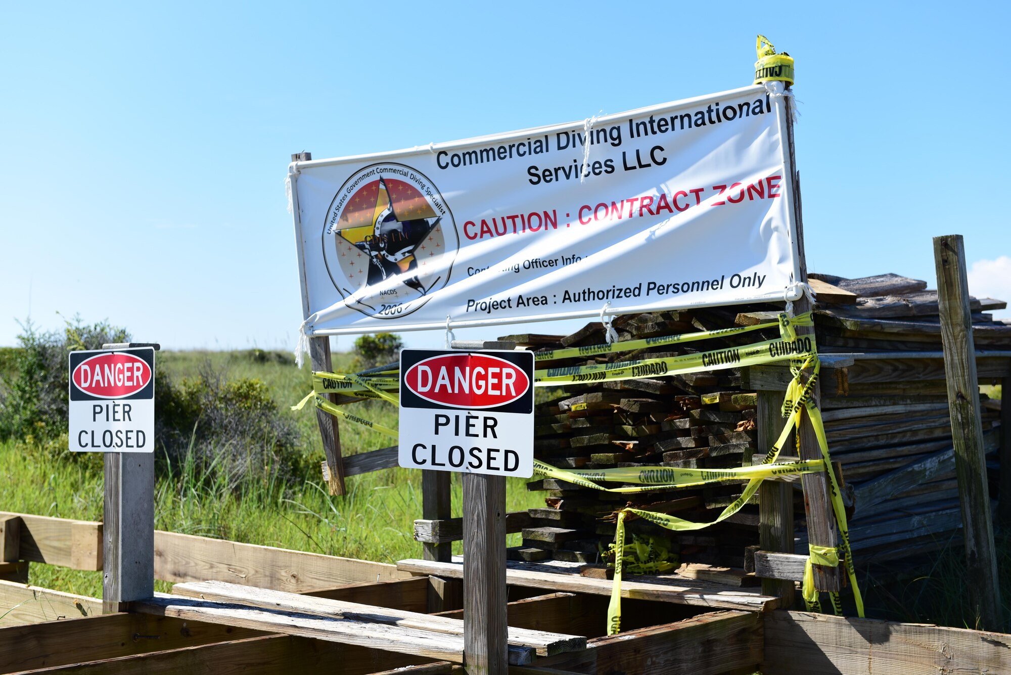 A sign set up by Commercial Diving International Services sits on a deconstructed boardwalk at Shell Island, Fla., Aug. 10, 2017. The construction on the pier and boardwalk on the Tyndall side of Shell Island began July 31, 2017, and is scheduled to be completed before Labor Day 2017.