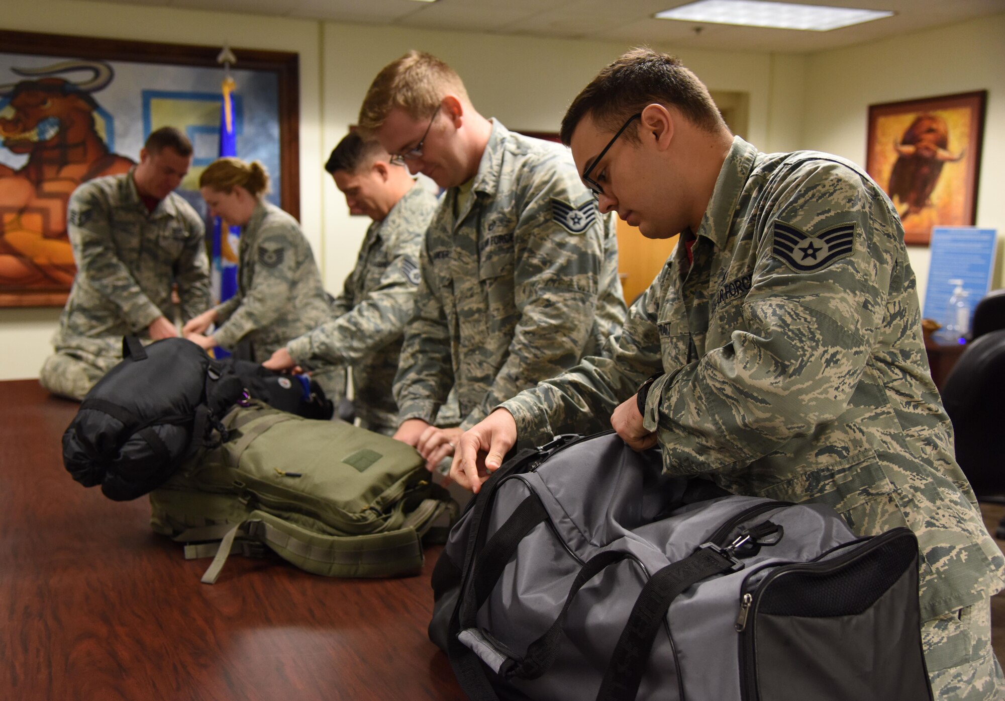 Staff Sgt. Robert Pratt, 335th Training Squadron instructor, and other shelter security augmentees inspect Airmen’s personal bags as they process into Wolfe Hall for sheltering during a hurricane exercise Aug. 11, 2017, on Keesler Air Force Base, Miss. Each year Keesler personnel participate in exercise scenarios like this to ensure they can respond to a hurricane threat. (U.S. Air Force photo by Kemberly Groue)