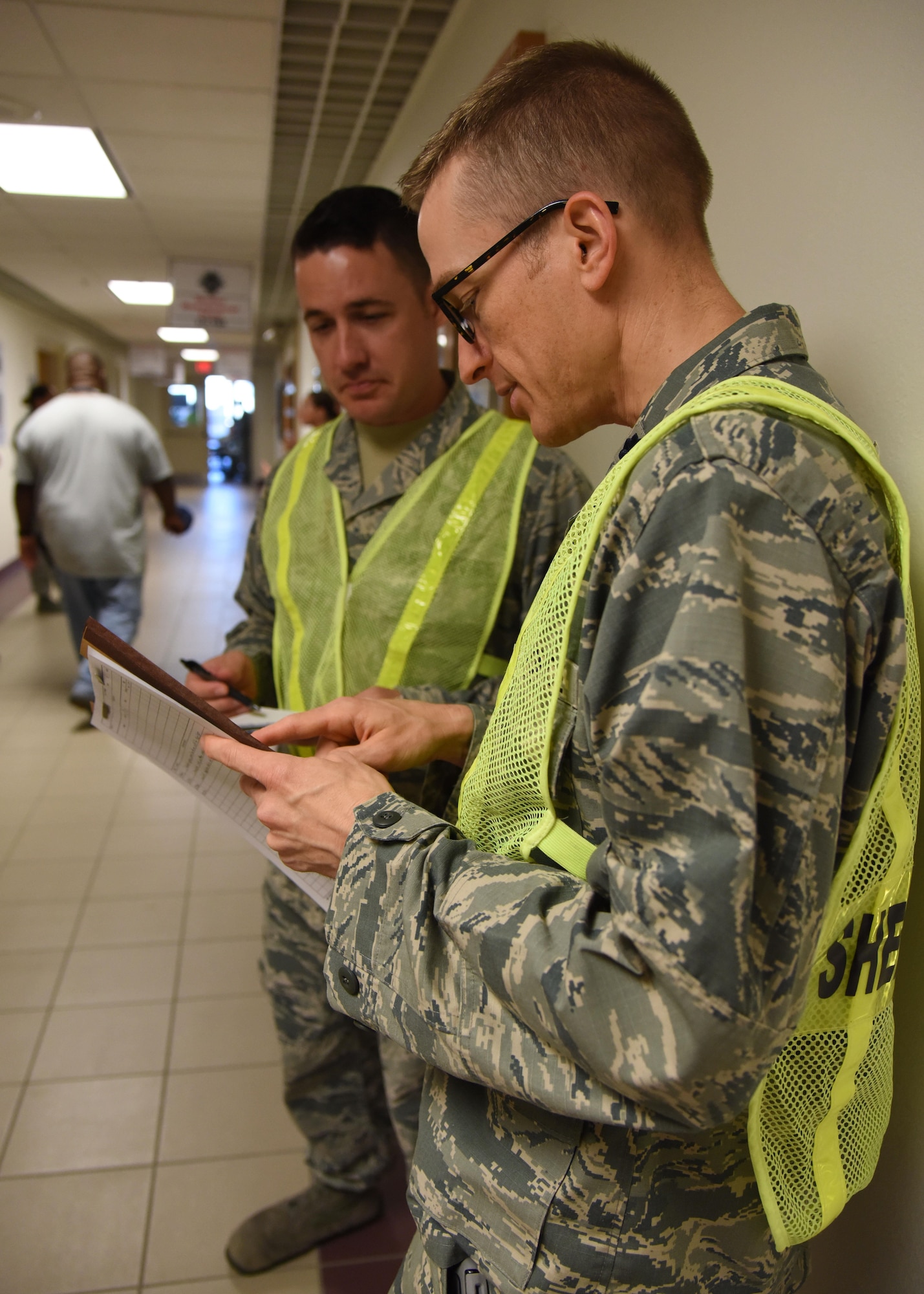 Master Sgt. Michael Rowley, 335th Training Squadron instructor supervisor, and Lt. Col. Steve Lipinski, 335th TRS commander, review an accountability list for Airmen who are sheltering in Wolfe Hall during a hurricane exercise Aug. 11, 2017, on Keesler Air Force Base, Miss. Each year Keesler personnel participate in exercise scenarios like this to ensure they can respond to a hurricane threat. (U.S. Air Force photo by Kemberly Groue)