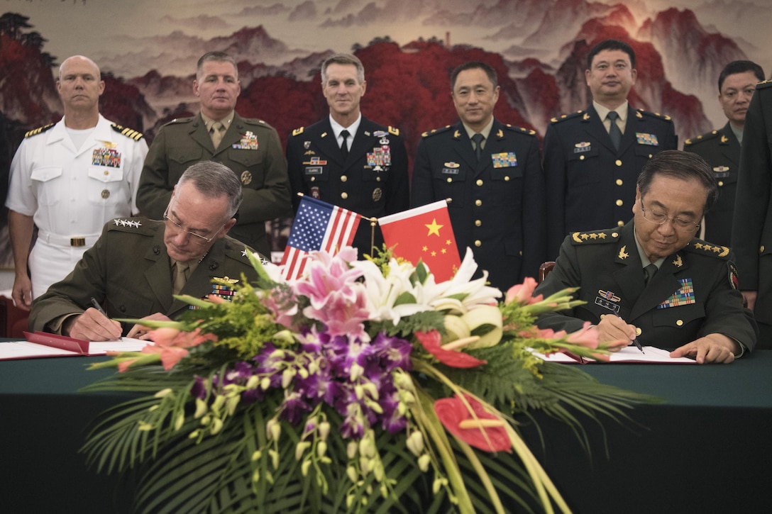 Military leaders sign an agreement.