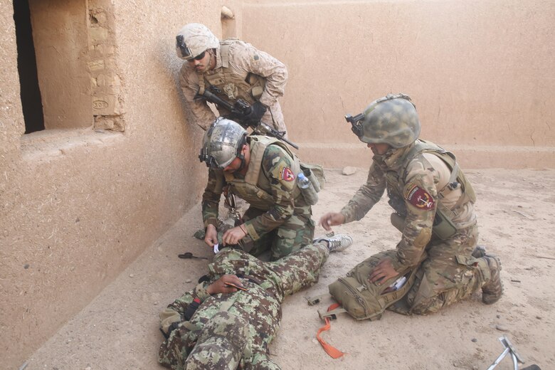 An Afghan National Army soldier with 215th Corps applies a tourniquet to a notionally-injured soldier during casualty evacuation training at Camp Shorabak, Afghanistan, Aug. 14, 2017. Several ANA units practiced their CASEVAC procedures in preparation for future real-world operations. Quickening the CASEVAC process vastly improves survivability and recovery rates for wounded personnel. (U.S. Marine Corps photo by Sgt. Lucas Hopkins)