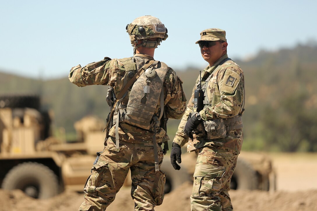 Army Capt. Gustavo Madrigal works with a Army Reservist