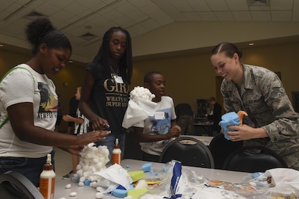 Senior Airman Allyson Walker-Cramer, 628th Civil Engineer Squadron engineer assistant, right, helps out a few of the kids attending the Science, Technology, Engineering and Mathematics event at the Chapel Annex in Joint Base Charleston, S.C., Aug. 14.