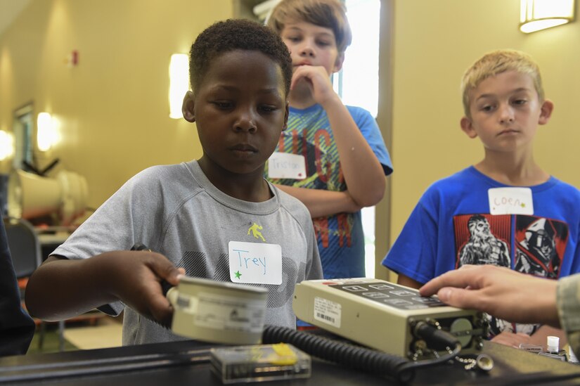 Trey Edmond, a Science, Technology, Engineering and Mathematics Day participant, left, tests the radiation levels from a sample demonstration from 628th Medical Group biomedical technicians at the Chapel Annex in Joint Base Charleston, S.C., Aug. 14.