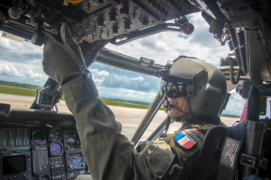 Commandant Micka, a French exchange pilot and assistant director of operations for Moody’s 41st Rescue Squadron, actuates switches in a HH-60G Pavehawk, Aug. 2, 2017, at Moody Air Force Base, Ga. Prior to his arrival at the 41st RQS, Micka transitioned from flying the French Air Force’s EC-725 Caracal helicopter to learn the HH-60. Since his childhood, Micka aspired to serve and fly for the French and U.S. military as a rescue pilot. (U.S. Air Force photo by Senior Airman Greg Nash)