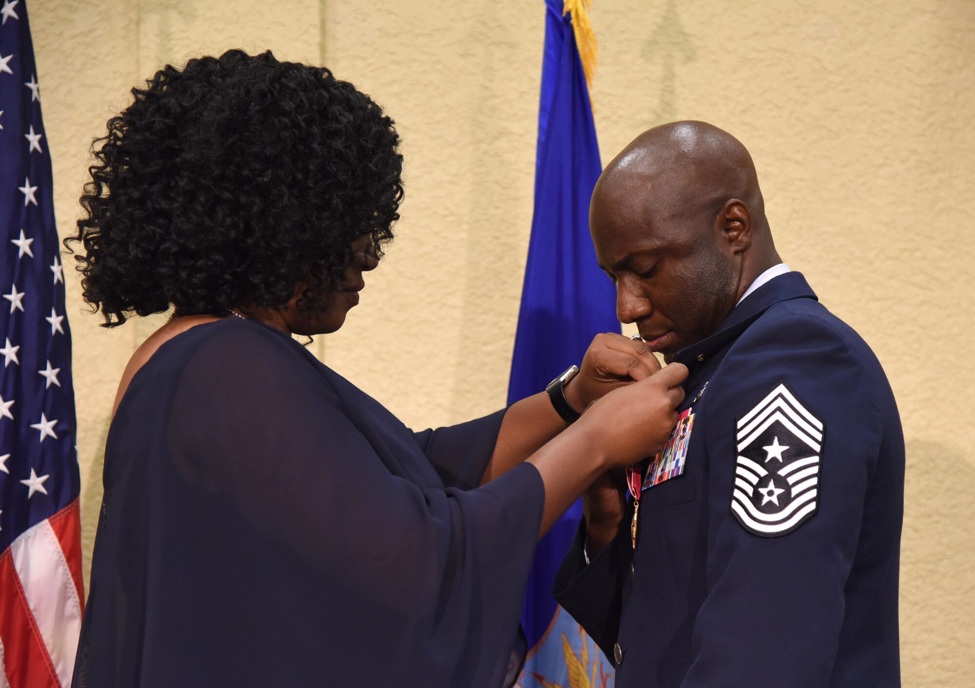 Laurice Clark pins her husband, Chief Master Sgt. Vegas Clark, former 81st Training Wing command chief, with a retirement pin during his retirement ceremony in the Bay Breeze Event Center Aug. 11, 2017, on Keesler Air Force Base, Miss. Clark retired with 22 years of military service. Prior to his assignment at Keesler he served as the command chief for the 39th Air Base Wing, Incirlik Air Base, Turkey. (U.S. Air Force photo by Kemberly Groue)