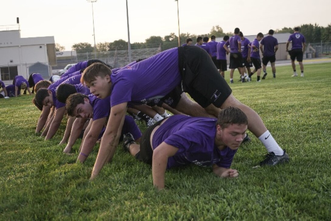 Students with the Grand Island Senior High School football team complete a workout led by Marine Corps recruiters in Grand Island, Neb. Aug. 2, 2017. The camps allow Marines to teach the importance of our core values to young athletes across the nation.