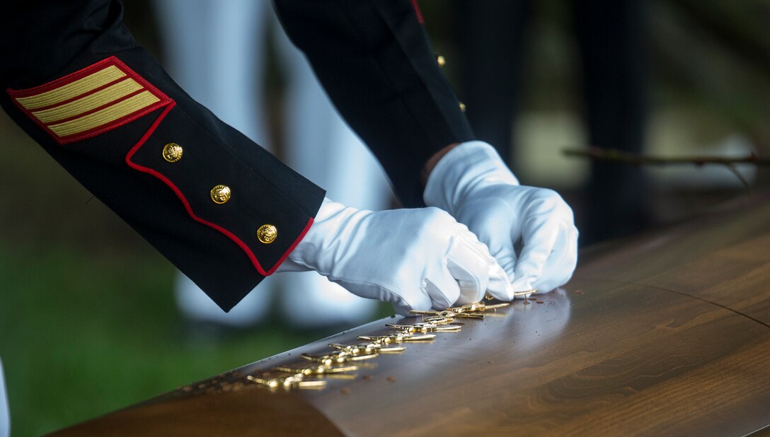 A Marine pounds his Marine Special Operator Insignia into the casket of fallen Marine Sgt. Joseph J. Murray during a funeral for Murray at Arlington National Cemetery, Arlington, Va., Aug. 15, 2017. Murray, 26, was one of the 15 Marines and one Navy sailor who perished when their KC130-T Hercules crashed in Mississippi, July 10, 2017. Murray was a Critical Skills Operator with the 2nd Raider Battalion, Marine Corps Forces Special Operations Command (MARSOC).  It is tradition in the Special Operations community for fellow members of the fallen veteran’s unit to pound their insignia into the casket as a sign of never leaving their side and a final show of respect. (Official U.S. Marine Corps photo by Cpl. Robert Knapp/Released)