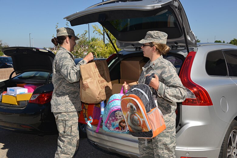 1st Lt. Christiana Fairman and 2nd Lt. Billie DeLuca of the Air Force Nuclear Weapons Center load more than $3,500 in donated school supplies from AFNWC for delivery to three local Title-I schools.