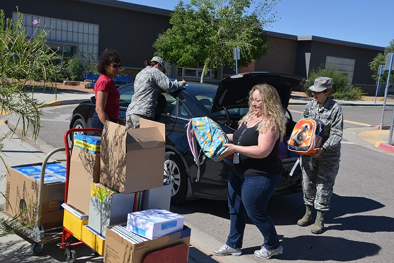 Volunteers from the Air Force and local communities unload supplies donated to the Title-I school for the upcoming year.