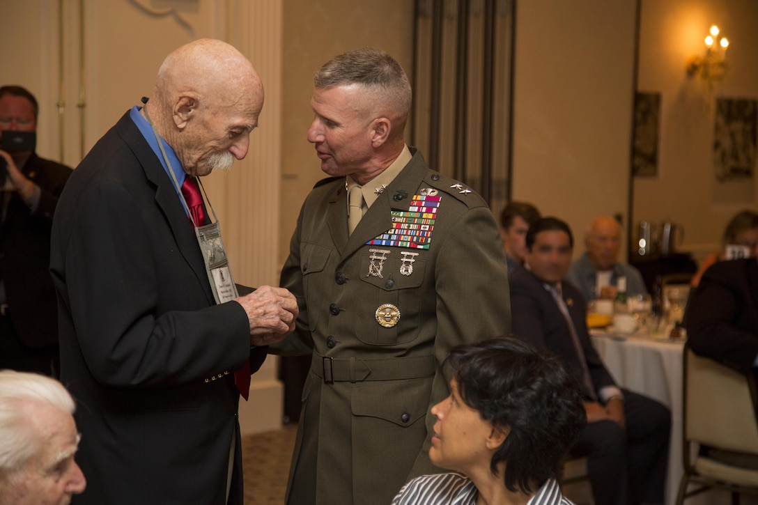 Maj. Gen. Eric M. Smith, 1st Marine Division commander, gives James W. Campbell, a World War II Raider, a gift from his recent trip to Guadalcanal during 2017 Marine Raider Association Reunion in San Diego, Aug. 11. Seventeen World War II Raiders attended the annual event at the San Diego Town and Country Resort, San Diego, where the USMRA hosted a 1940s USO-style dinner and dance for Marine Raiders of past and present. (U.S. Marine Corps photo by Sgt. Salvador R. Moreno, released)