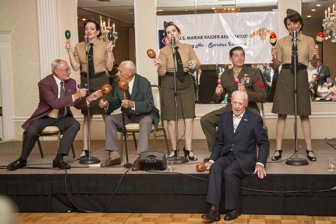 Harold S. Sheffield and Henry Kudzik, World War II Raiders, sit on the stage and participate in the entertainment portion of the evening with The Lindy Sisters during the 2017 Marine Raider Association Reunion in San Diego, Aug. 11. Seventeen World War II Raiders attended the annual event at the San Diego Town and Country Resort, San Diego, where the USMRA hosted a 1940s USO-style dinner and dance for Marine Raiders of past and present. (U.S. Marine Corps photo by Sgt. Salvador R. Moreno, released)