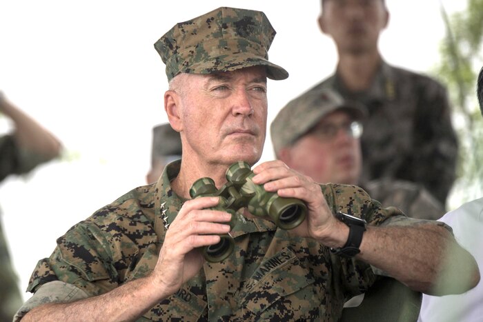 A Marine Corps officer holds a pair of binoculars.