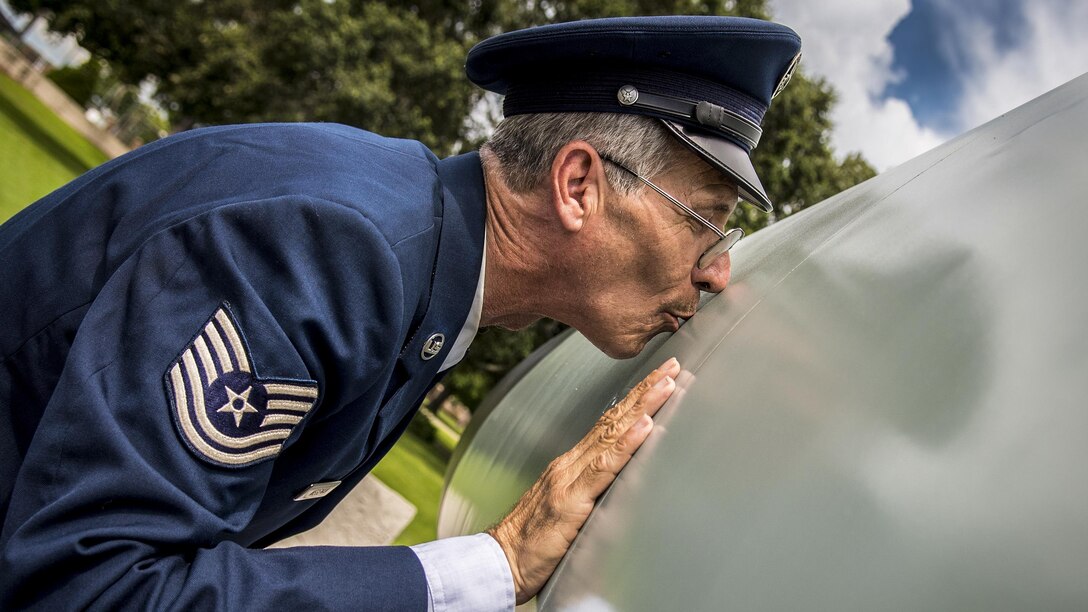 An airman kisses his previous aircraft before he retires after 41 years.