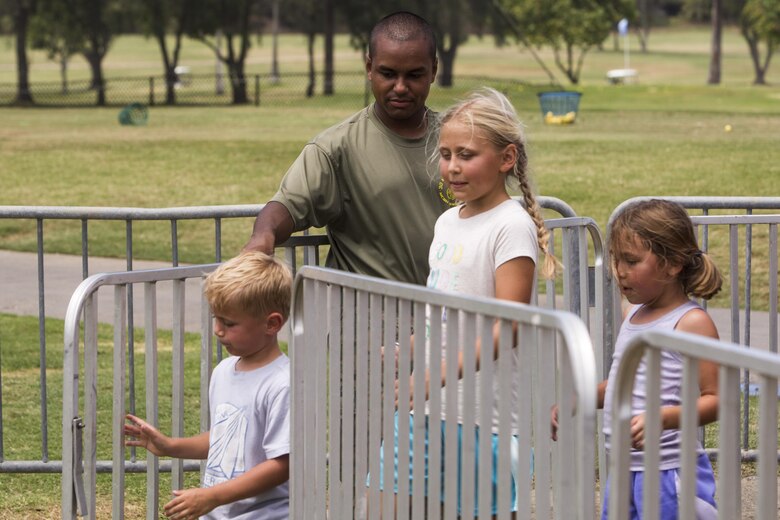 Cpl. Samuel Sepulveda, a supply clerk with 3rd Marine Regiment, helps children exit a fair ride during the Klipper Summer Bash at the Klipper Golf Course aboard Marine Corps Base Hawaii, July 28, 2017. The Summer Bash is an annual event hosted by the Klipper Golf Course to strengthen a sense of community amongst residents of MCB Hawaii. (U.S. Marine Corps photo by Lance Cpl. Isabelo Tabanguil)