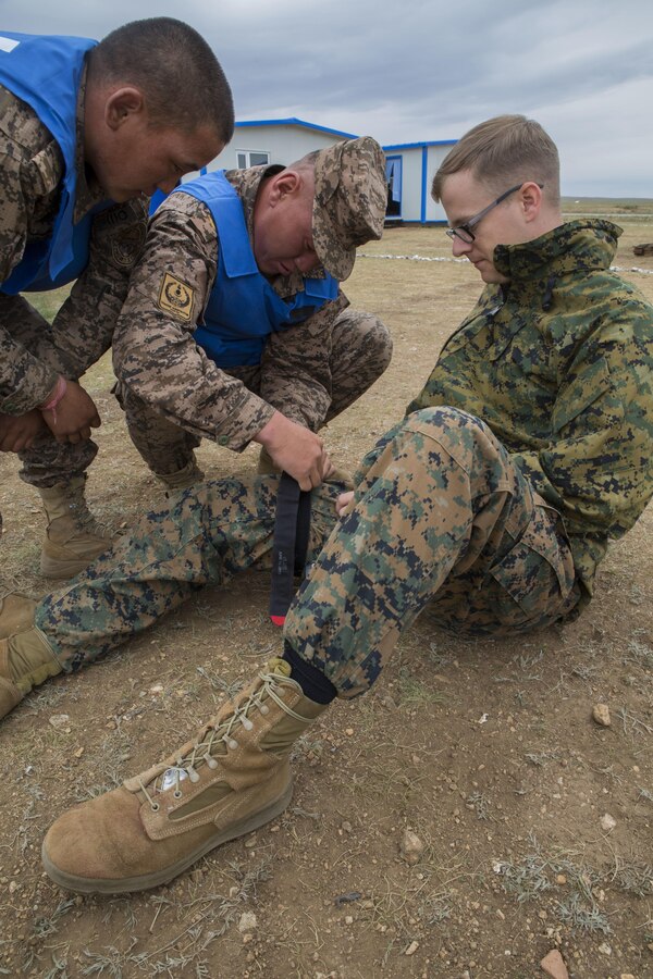 Service members in the Mongolian Armed Forces take turns applying a tourniquet to U.S. Navy Petty Officer 3rd Class James Crouch for a practical application of tactical combat casualty care during Exercise Khaan Quest 2017 at Five Hills Training Area, Mongolia, July 24, 2017. Khaan Quest 2017 is a Mongolian-hosted, combined, joint training exercise designed to strengthen the capabilities of the U.S., Mongolia and other partner nations in international peacekeeping operations. Crouch, from Windsor, Connecticut is a hospital corpsman with 3rd Medical Battalion, 3rd Marine Logistics Group, III Marine Expeditionary Force.  (U.S. Marine Corps photo by Lance Cpl. Charles Plouffe)