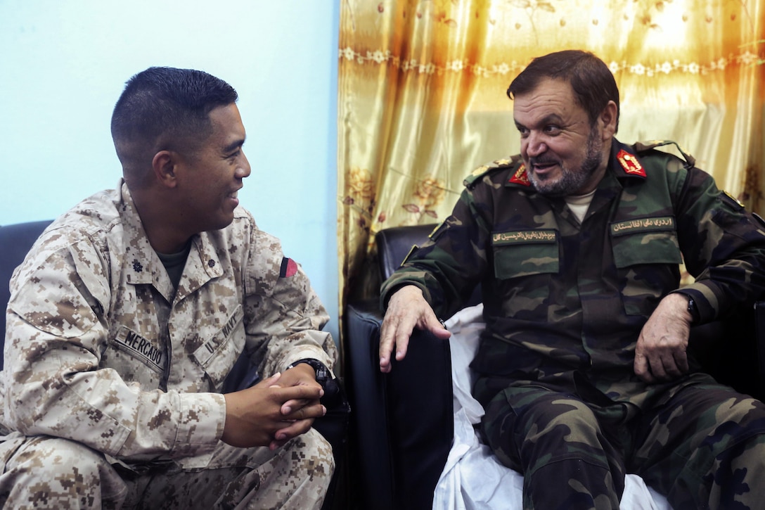 An American surgeon and medical advisor speaks with Afghan National Army soldier.