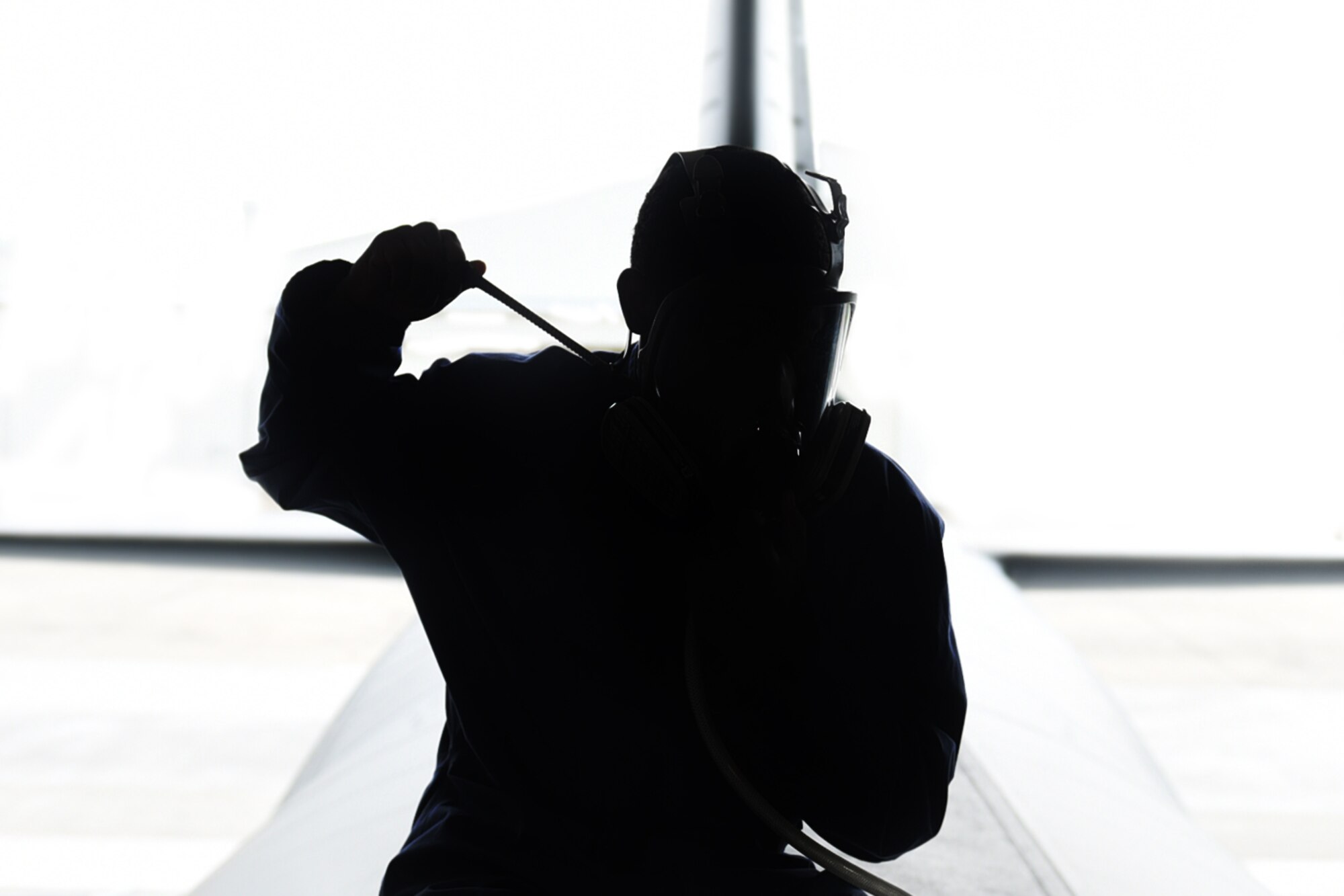 Senior Airman Stefan Stephenson-Shipp, 19th Maintenance Squadron fuel systems journeyman, dons an air respirator before entering a C-130J dry bay Aug. 8, 2017, at Little Rock Air Force Base, Ark. Fuels Airmen wear respirators, coveralls, boots and gloves to protect their face and skin from hazardous materials they come into contact with on the job. (U.S. Air Force photo illustration by Airman 1st Class Kevin Sommer Giron)