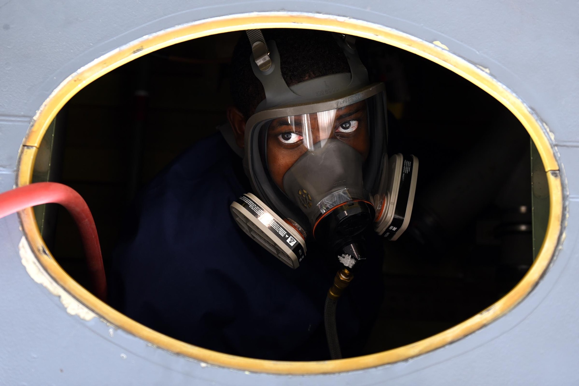 Senior Airman Stefan Stephenson-Shipp, 19th Maintenance Squadron fuel systems journeyman, enters a C-130J dry bay to reinstall a fuel manifold August 8, 2017, at Little Rock Air Force Base, Ark. All personnel entering a fuel tank or dry bay with open fuel lines are required to have a supplied air respirator on to prevent exposure to fumes. (U.S. Air Force photo by Airman 1st Class Kevin Sommer Giron)