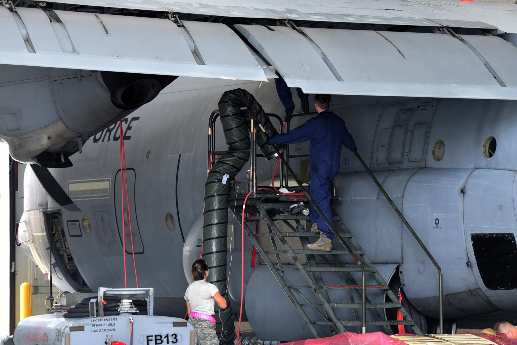 Airmen from the 19th Maintenance Squadron Fuels Flight enter a C-130J fuel tank Aug. 8, 2017, at Little Rock Air Force Base, Ark. Three Airmen are required to perform maintenance on the fuel tanks at all times. Their positions are: the attendant, the entrant and the runner. The entrant is in charge of maintenance, the attendant is responsible for overseeing the well-being of the entrant during the process and the runner gathers tools. The entrant checks for leaks and parts that aren’t operating properly and makes repairs. (U.S. Air Force photo by Airman 1st Class Kevin Sommer Giron)