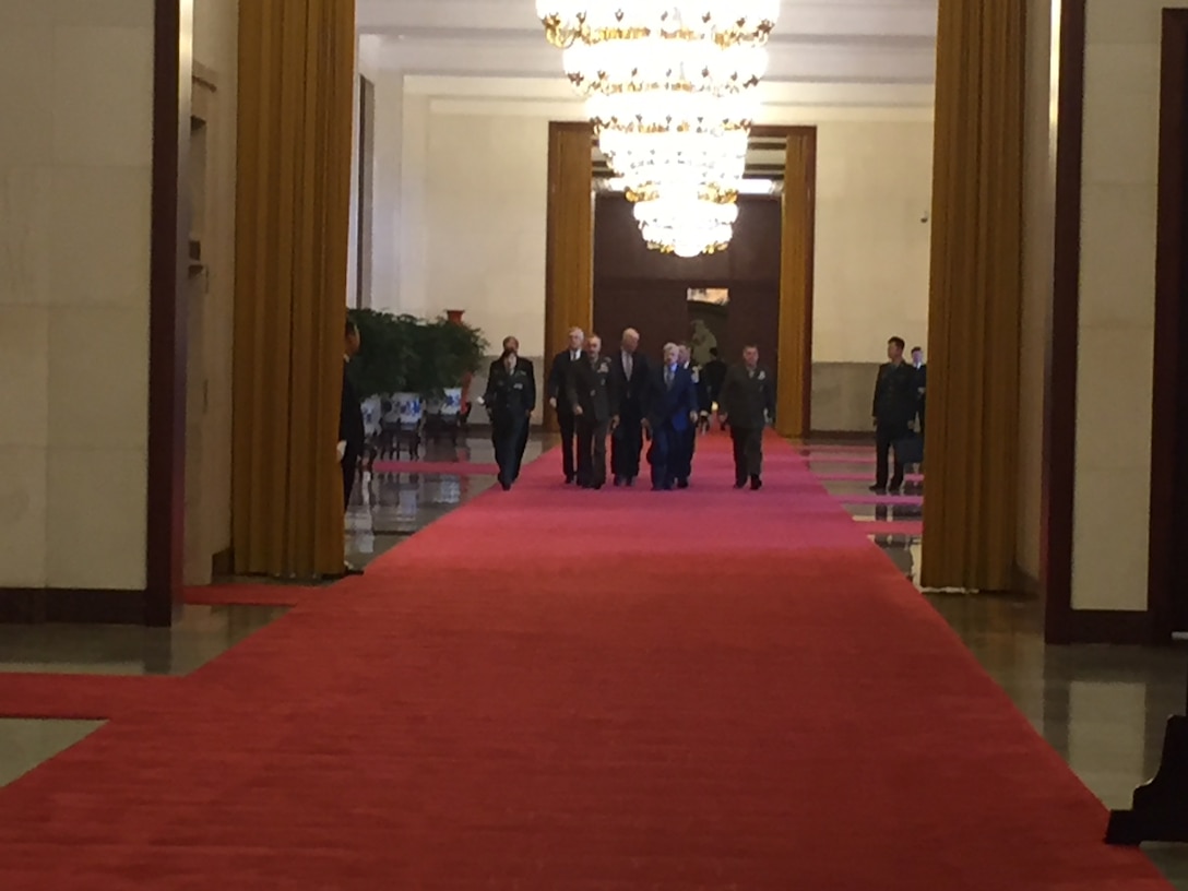 The chairman of the Joint Chiefs of Staff, walks with his team through the Great Hall of the People in Beijing.