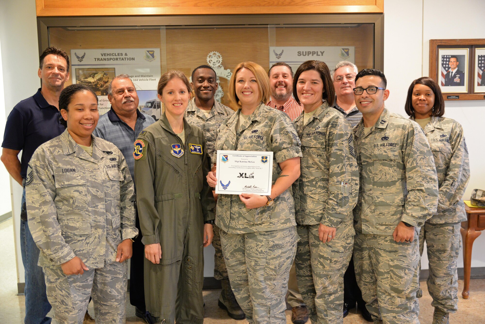 Staff Sgt. Katrina McGee, 47th Logistics Readiness Squadron plans and integration NCOIC, presents her award from wing leadership Aug. 14.