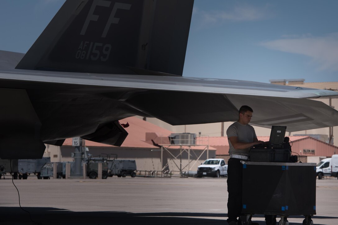 U.S. Air Force Airman Juan Luna, 94th Aircraft Maintenance Unit crew chief, reviews technical orders, while preparing to launch an F-22 Raptor during Red Flag 17-4, at Nellis Air Force Base, Nev. , Aug. 14, 2017. (U.S. Air Force photo/Staff Sgt. Carlin Leslie)