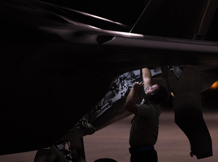 Airman 1st Class Jeremy Weymouth, 94th Aircraft Maintenance Unit crew chief, inspects the rear wheel well, during night operations for Red Flag 14-7 at Nellis Air Force Base, Nev., August 14, 2017. (U.S. Air Force Photo/Staff Sgt. Carlin Leslie)