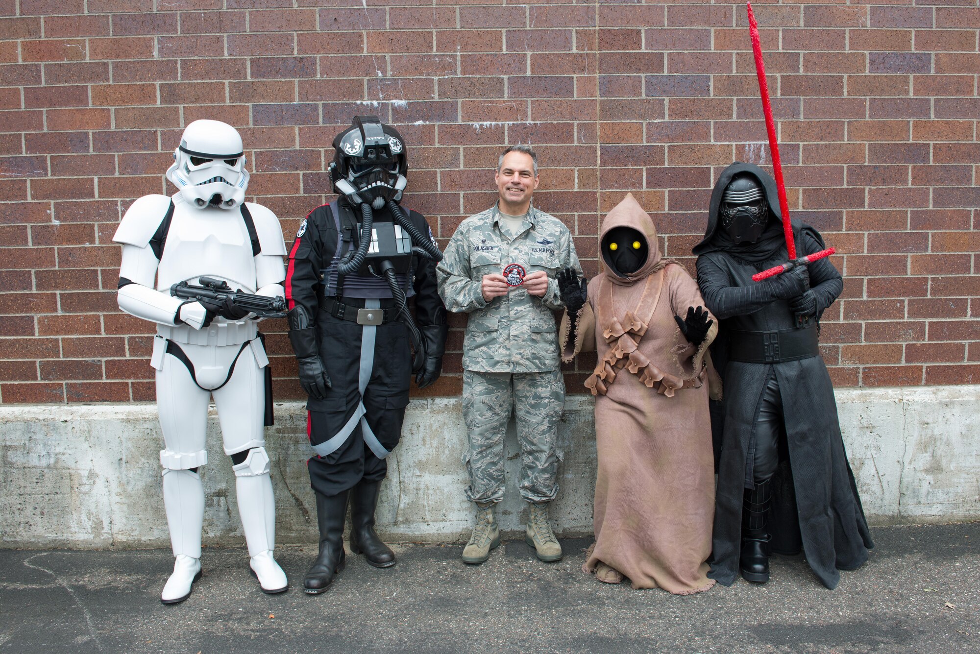 Star Wars characters present Col. Tony Polashek, 934th Airlift Wing commander, with a 501st organizational patch. (Air Force Photo/Master Sgt. Eric Amidon)