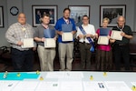 (From left to right) Defense Language Institute instructors David Britton, Chad Hamilton, Chad Kallauner, Reza Keivanzadeh, Carole Franki, and Earl Gaston pose for a group photo with their awards Aug. 4, 2017 at Joint Base San Antonio-Lackland, Texas. The instructors each received an award for an eternal safety campaign they held in conjunction with their 101 Critical Days of Summer Safety brief. Keivanzadeh received a trophy for having the highest unit participation.