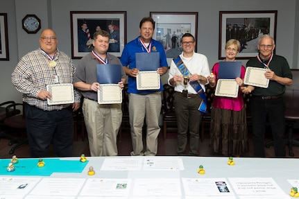 (From left to right) Defense Language Institute instructors David Britton, Chad Hamilton, Chad Kallauner, Reza Keivanzadeh, Carole Franki, and Earl Gaston pose for a group photo with their awards Aug. 4, 2017 at Joint Base San Antonio-Lackland, Texas. The instructors each received an award for an eternal safety campaign they held in conjunction with their 101 Critical Days of Summer Safety brief. Keivanzadeh received a trophy for having the highest unit participation.