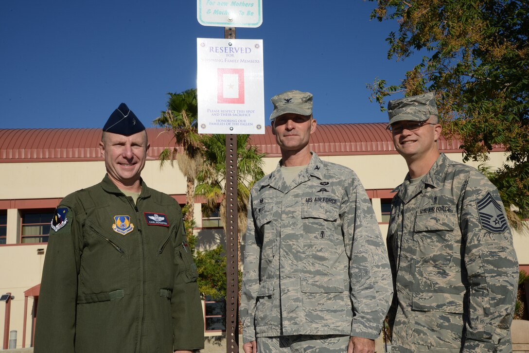 Brig. Gen. Carl Schaefer, 412th Test Wing commander, Col. Norm West, 412th Medical Group commander, and Chief Master Sgt. Donald Cook, 412th MDG superintendent, display the new Gold Star Family parking space in front of Edwards Main Clinic. (U.S. Air Force Photo by Christopher Ball)