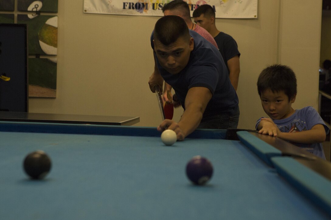 MCAS FUTENMA, OKINAWA, Japan— Lance Cpl. Abraham Espinoza plays pool during the 6th Marine Corps Air Station Futenma English Discussion class party Aug. 15 at the United Service Organization building on MCAS Futenma, Okinawa, Japan.