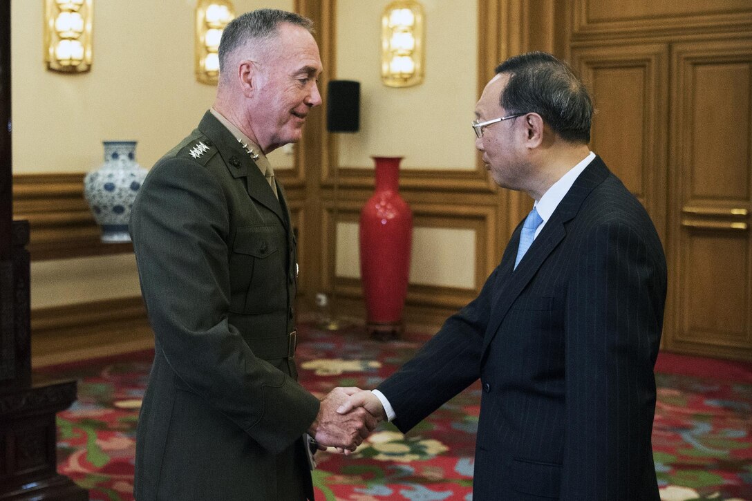 Two men shake hands during a meeting in China.