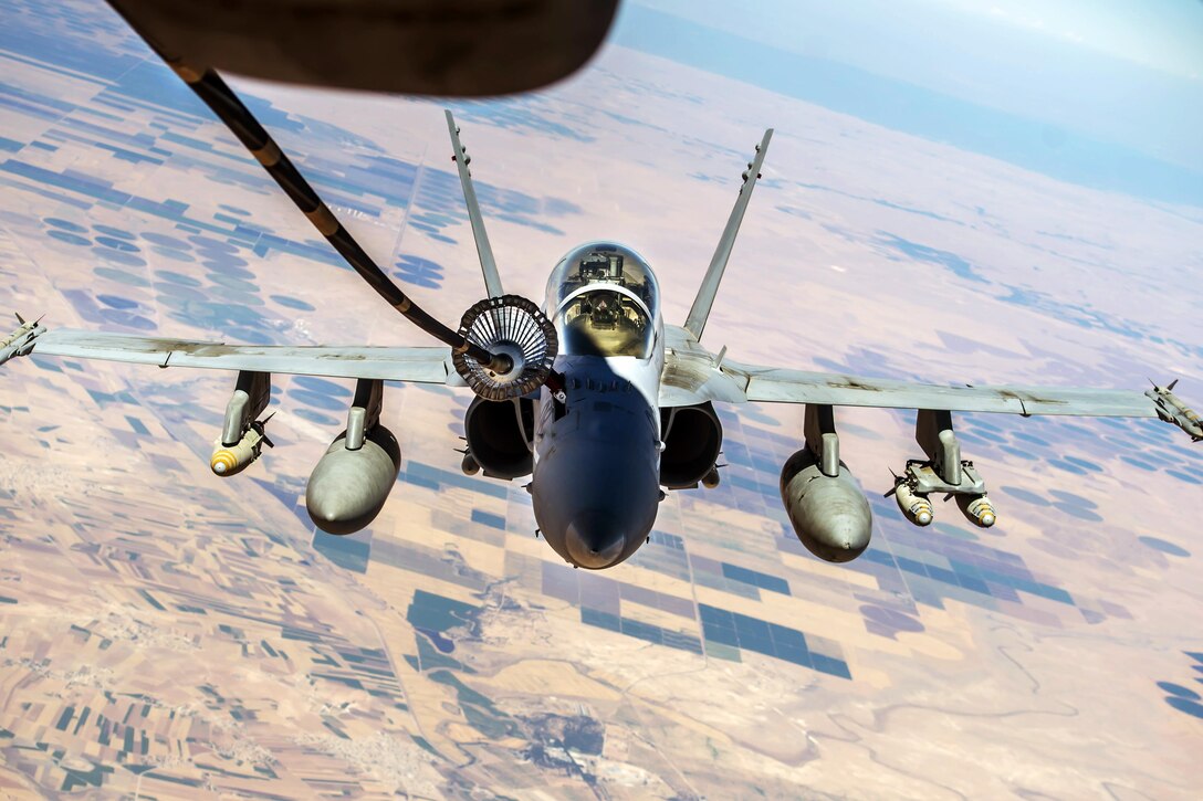 A military aircraft receives fuel in midair.