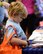 A young member of Team Whiteman looks at an Airman & Family Readiness Center informational booklet during the Back-to-School Brigade event at Whiteman Air Force Base, Mo., Aug. 8, 2017. Students were given tote bag to fill with school supplies and resources to help them start the new school year off right. (U.S. Air Force photo by Staff Sgt. Danielle Quilla)