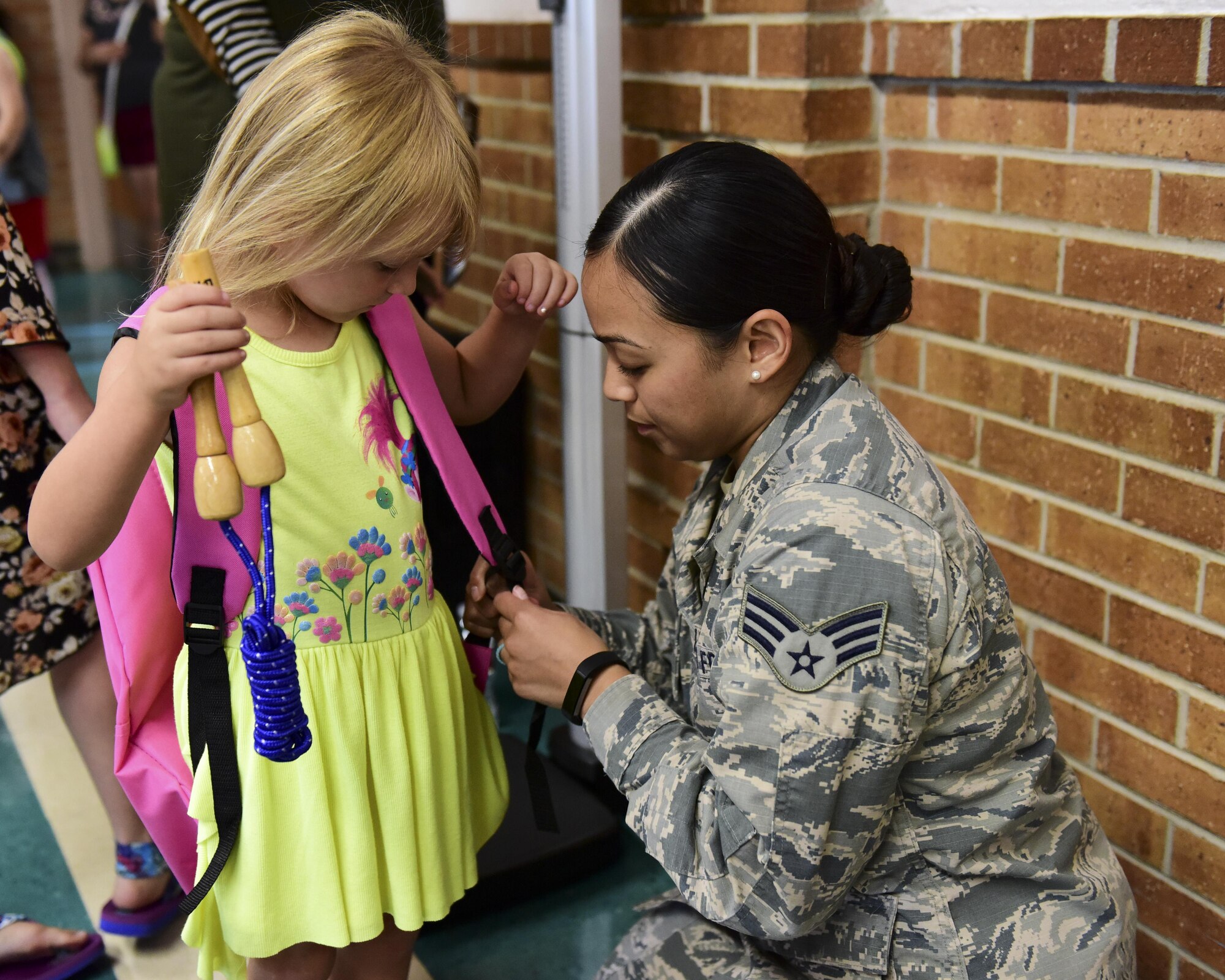 U.S. Air Force Senior Airman Tiffani-Amber Petit, a physical therapy technician with the 509th Medical Operations Squadron, right, helps adjust the backpack straps for Delilah Gordon, a pre-kindergarten student who is the daughter of Staff Sgt. Samuel Gordon, during the Back-to-School Brigade event at Whiteman Air Force Base, Mo., Aug. 8, 2017. Petit made sure the backpack fit comfortably and did not weigh more than 10 percent of the student’s bodyweight. (U.S. Air Force photo by Staff Sgt. Danielle Quilla)