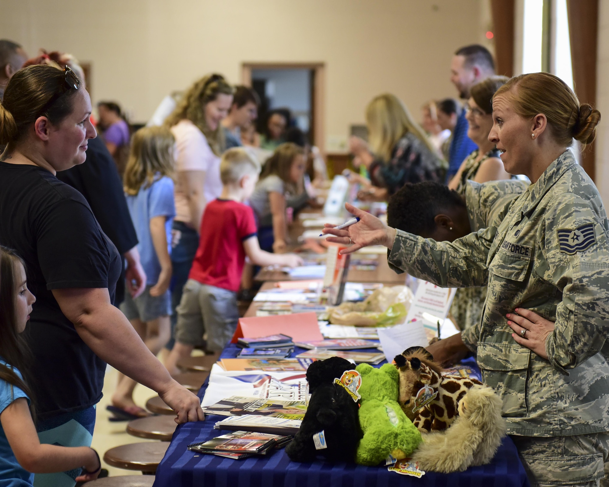 U.S. Air Force Tech. Sgt. Kira Otero, a readiness NCO with the Airman & Family Readiness Center (A&FRC), speaks to a family about the programs the center offers during the Back-to-School Brigade event at Whiteman Air Force Base, Mo., Aug. 8, 2017. In addition to the A&FRC, programs such as Child Care Aware and Exceptional Family Member Program were present to help ensure families had all the resources they needed to make it a successful school year. (U.S. Air Force photo by Staff Sgt. Danielle Quilla)