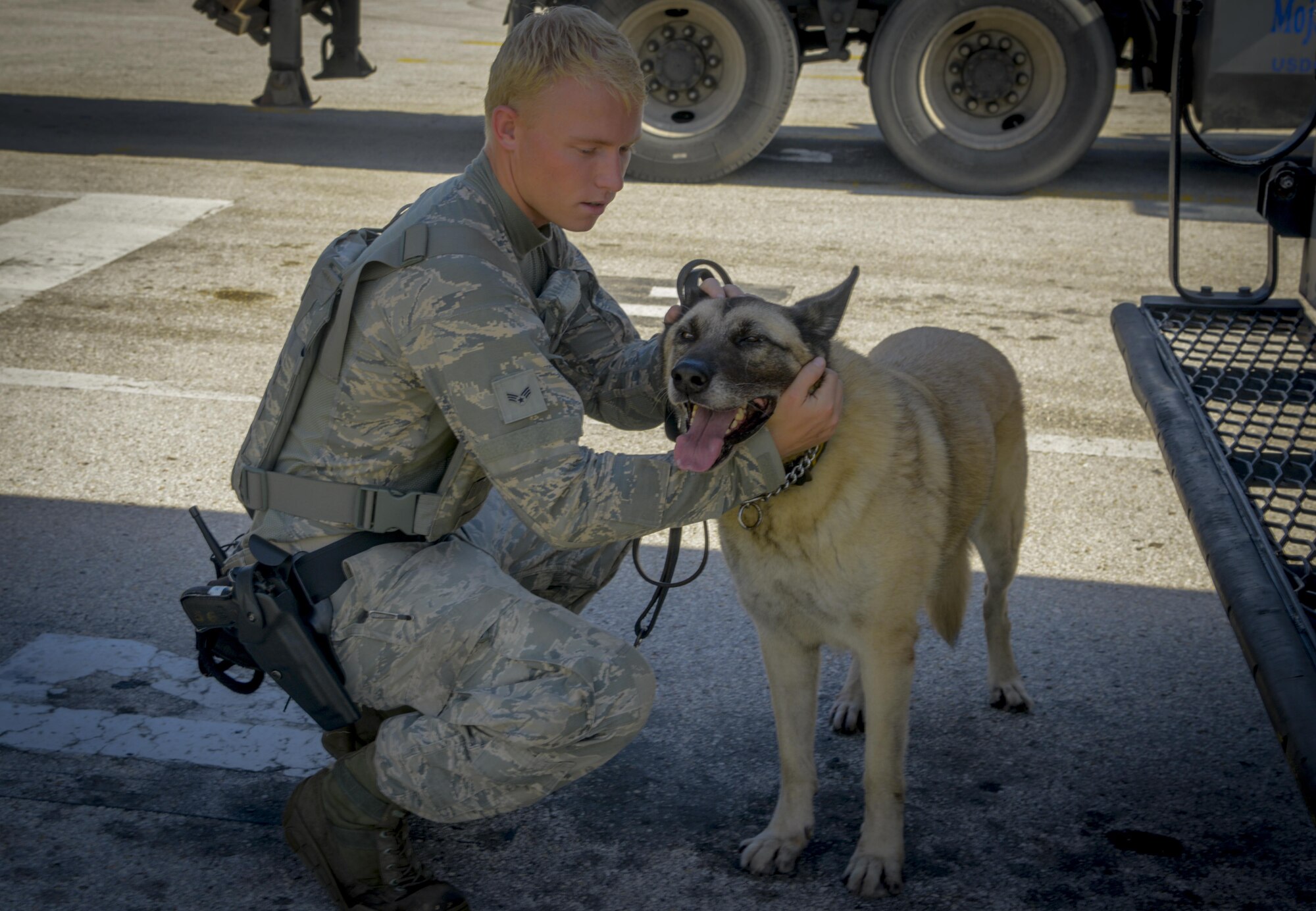 U.S. Air Force Senior Airman Brian Loughmiller, a military working dog handler assigned to the 6th Security Forces Squadron, takes a break to comfort his partner Jecky, a military working dog, at MacDill Air Force Base, Fla., Aug. 15, 2017. The dog and its handler develop a bond after working so many long hours together. (U.S. Air Force photo by Senior Airman Mariette Adams)