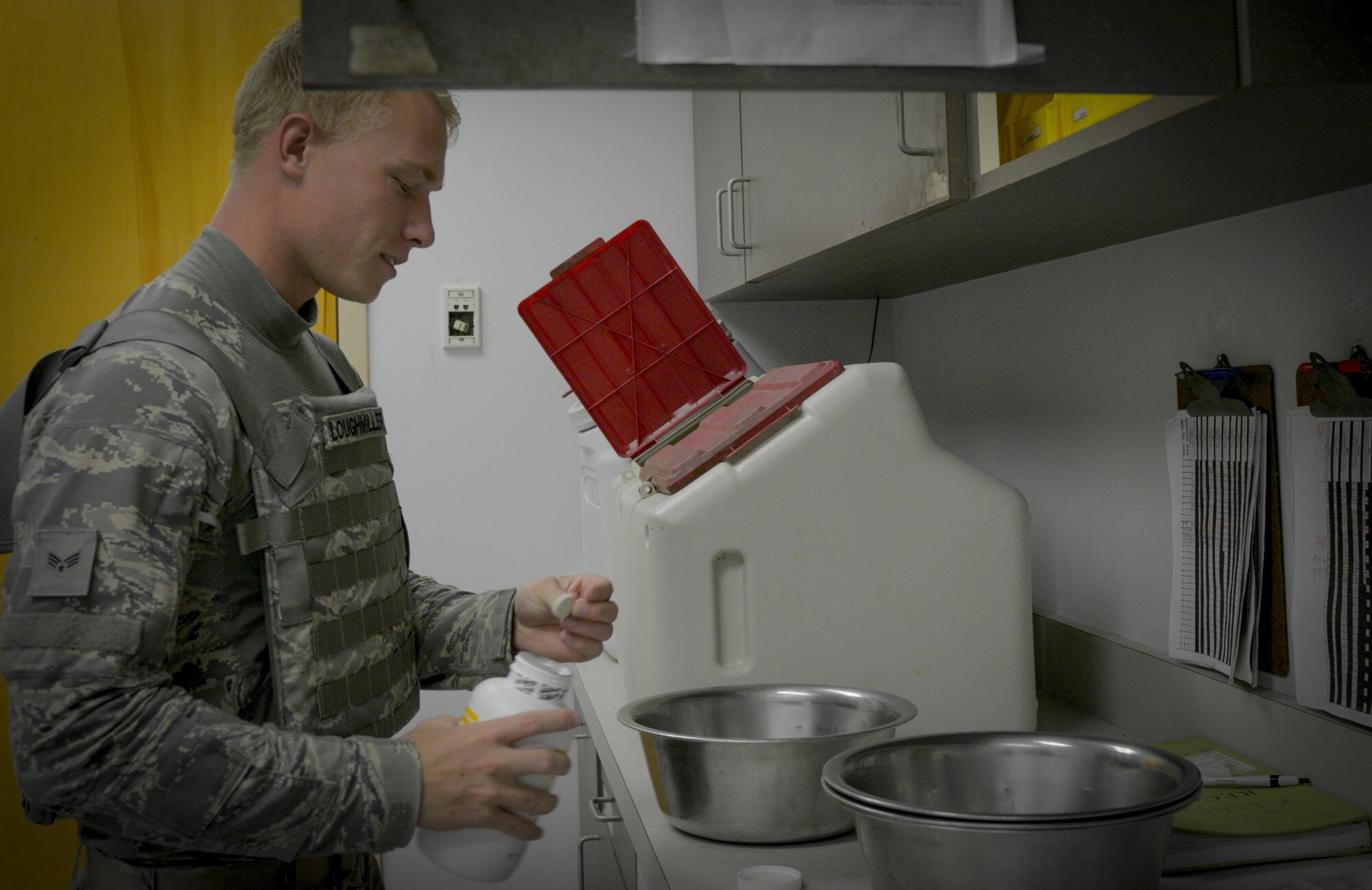 U.S. Air Force Senior Airman Brian Loughmiller, a military working dog handler assigned to the 6th Security Forces Squadron, dispenses medication into a dog’s food bowl at MacDill Air Force Base, Fla., Aug. 15, 2017. Handlers are responsible for keeping the kennels clean, the dogs fed and dispensing necessary medication. (U.S. Air Force photo by Senior Airman Mariette Adams)