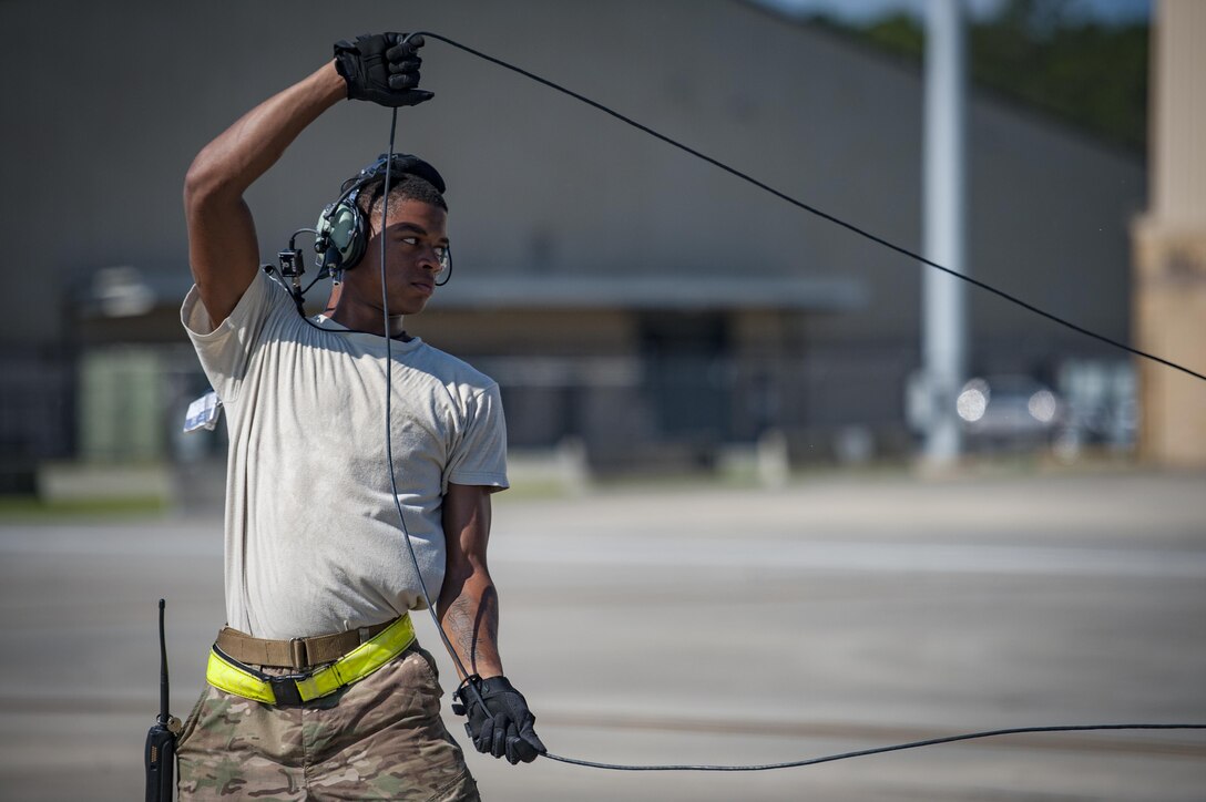 Senior Airman Tavaris Scott, 71st Rescue Squadron Aircraft Maintenance Unit crew chief, untangles a communications cord before launching an HC-130J Combat King II, Aug. 17, 2017, at Moody Air Force Base, Ga. Maintainers perform various tasks prior to take-off such as pre-flight inspections, removing plugs and covers, repairing any problems found during crew pre-flight checks and marshalling the aircraft. (U.S. Air Force photo by Airman 1st Class Lauren M. Sprunk)