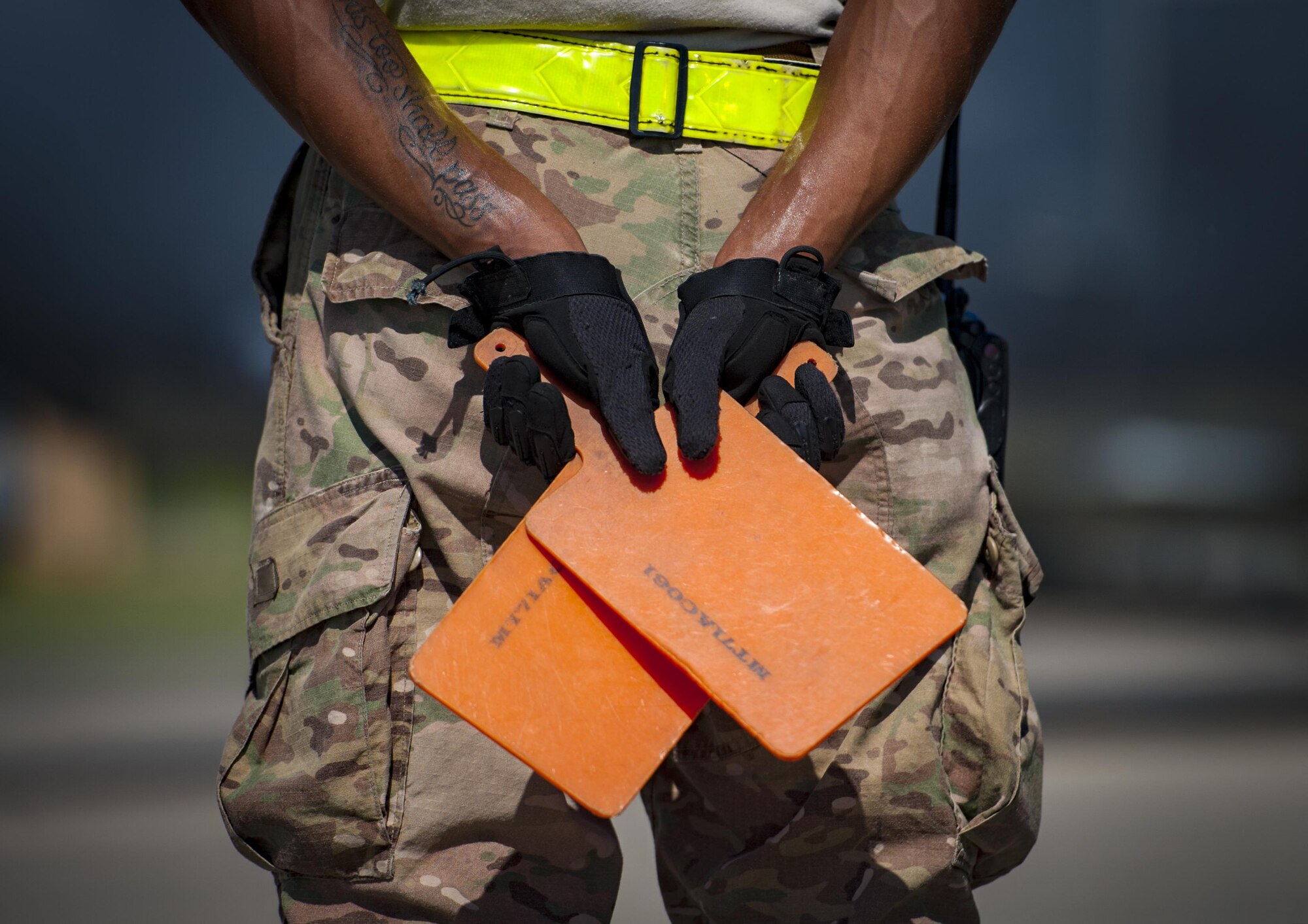Senior Airman Tavaris Scott, 71st Rescue Squadron Aircraft Maintenance Unit crew chief, holds marshalling sticks prior to launching an HC-130J Combat King II, Aug. 17, 2017, at Moody Air Force Base, Ga. Maintainers perform various tasks prior to take-off such as pre-flight inspections, removing plugs and covers, repairing any problems found during crew pre-flight checks and marshalling the aircraft. (U.S. Air Force photo by Airman 1st Class Lauren M. Sprunk)