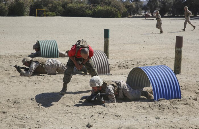 A drill instructor of Charlie Company, 1st Recruit Training Battalion, instructs a recruit to war cry while crawling through a tunnel during the Bayonet Assault Course at Marine Corps Recruit Depot San Diego, Aug. 8.