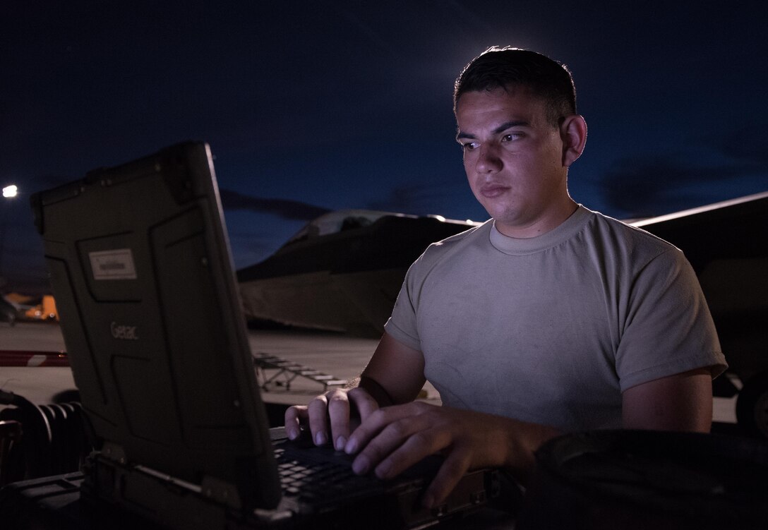 Airman Juan Luna, a crew chief with the 94th Aircraft Maintenance Unit, reviews technical orders while preparing to launch an F-22 Raptor during Red Flag 17-4, August 14, 2017, at Nellis AFB, Nev. Red Flag is a realistic combat training exercise involving the air, space and cyber forces of the United States and its allies. (U.S. Air Force photo/Staff Sgt. Carlin Leslie)