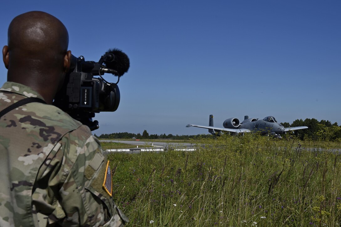 U.S. Army Sgt. Anril Baril, Armed Forces Network Europe broadcaster, records an A-10C Thunderbolt II aircraft Aug. 10, 2017, during a highway landing exercise at Jägala-Käravete Highway, Estonia. The flying training deployment is funded by the European Reassurance Initiative in support of Operation Atlantic Resolve. The U.S. Air Force’s forward presence in Europe allows the U.S. to work with allies and partners to develop and improve ready air forces capable of maintaining regional security. (U.S. Air National Guard photo by Airman 1st Class Sarah M. McClanahan)
