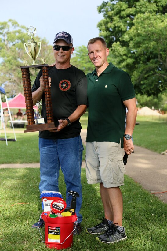 Colonel George W. Markert, Commanding Officer, Marine Corps Detachment Fort Leonard Wood, presents the winner “Best in Show” trophy for the 2nd year BBQ Bash and Auto Show to Daryl G. Reeves at Fort Leonard Wood, MO., June 23rd, 2017. (U.S. Marine Corps photo by Sgt. Teng Yang)