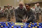 Airman Celeste Perry, 68th Network Warfare Squadron and youngest 24th Air Force Airman in San Antonio, joins Maj. General Chris Weggeman, 24th AF Commander, in cutting the cake to celebrate the NAF’s eighth birthday Aug 18, 2017, at Joint Base San Antonio-Lackland, Texas.